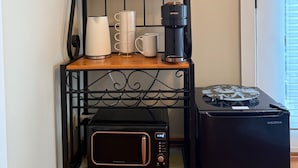 A kitchen area with a coffee maker, a microwave, and a shelf with labeled containers and glasses. - Beautiful Queen Suite near Castle, City & Beach (Victoria)