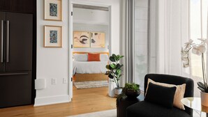 Ein modernes Wohnzimmer mit einem schwarzen Sofa, einem Esstisch und einem großen Fenster mit weißen Vorhängen.