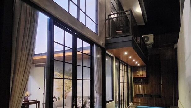 A modern indoor pool area with a stone floor, large sliding glass doors, and a small pool. - Sienna House Kerobokan (Kerobokan)