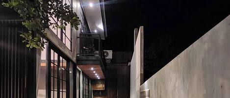 A modern outdoor pool area with a clear view of the pool, surrounded by a concrete wall and a glass fence.