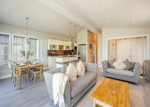 Ein modernes Wohnzimmer mit einer Couch, einem Couchtisch und einem Essbereich mit Stühlen und einem Tisch.