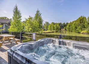 Een hottub met uitzicht op een meer en bomen.
