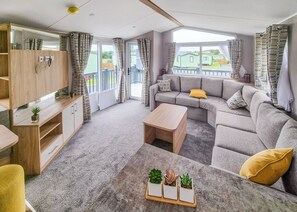 A modern living room with a sofa, coffee table, and a TV unit.