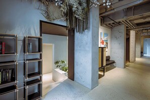 Ein modernes Interieur mit einem Metallregal, einer Betonstütze und einer Bank.