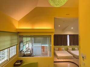A compact hotel room with a bathroom, a small sitting area, and a bed. - Win-win Villa (Dongshan)