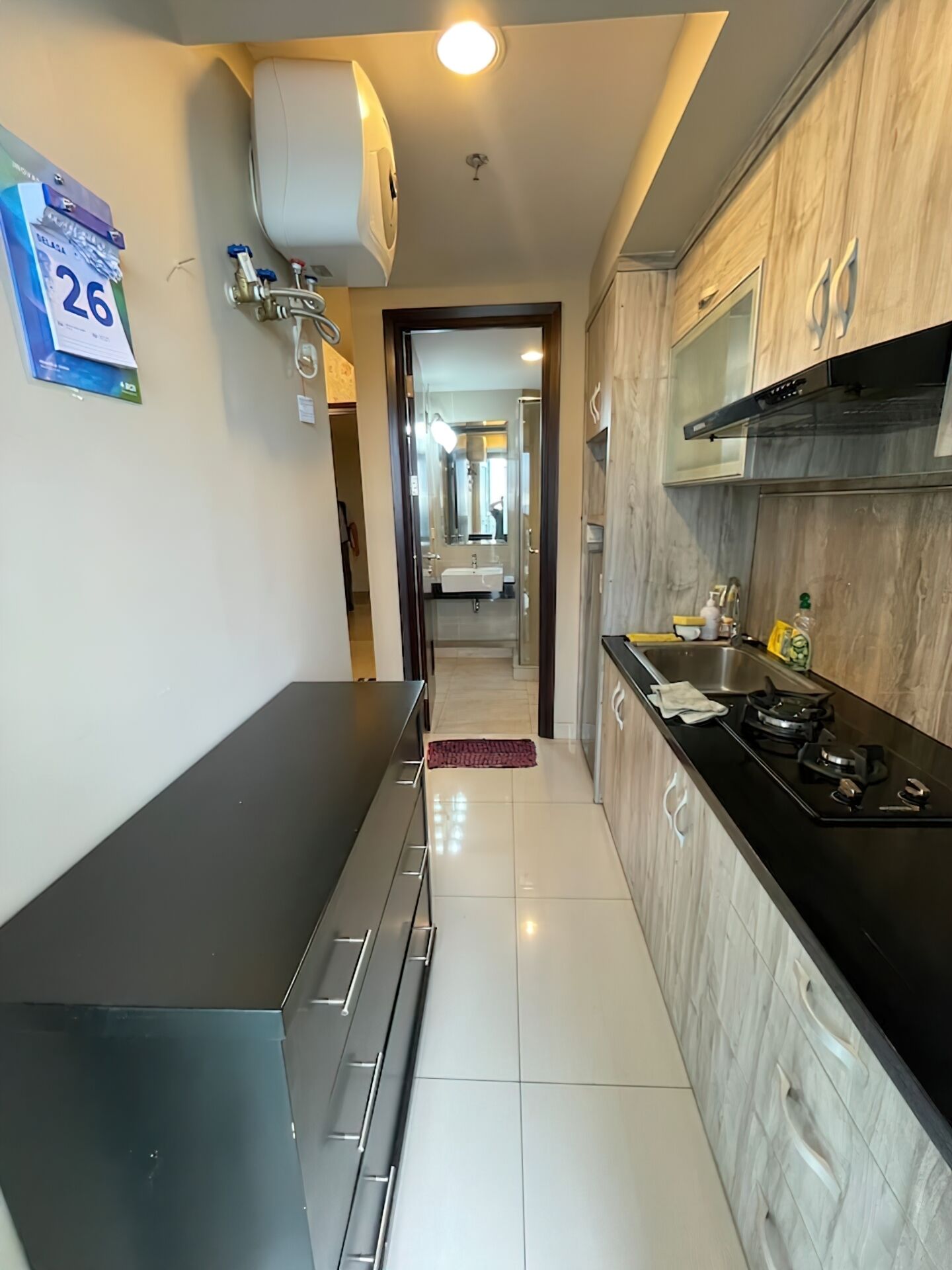 Cozinha moderna com bancada preta, eletrodomésticos de aço inoxidável e painel de azulejos.
