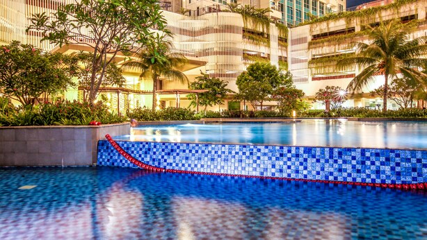 A swimming pool with blue mosaic tiles and a red rope barrier. - Staycation Jakarta Kensington Royal (Jakarta)