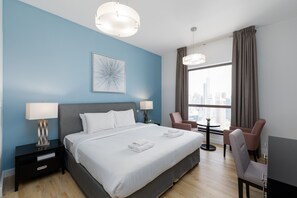 Een moderne hotelkamer met een groot bed, twee bedlampen, uitzicht op de stad, een bureau met stoel en een televisie.