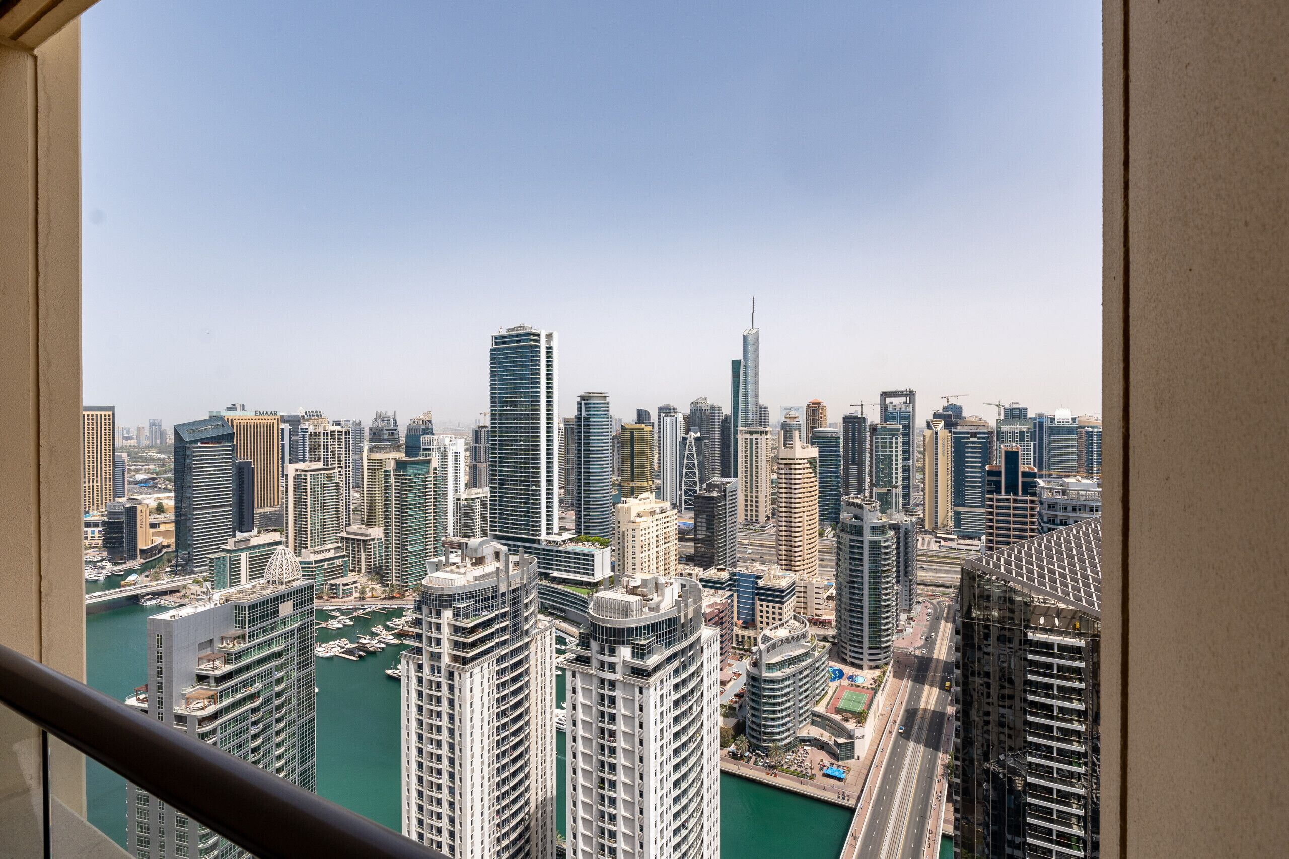 A cityscape with high-rise buildings, a marina, and a clear sky.