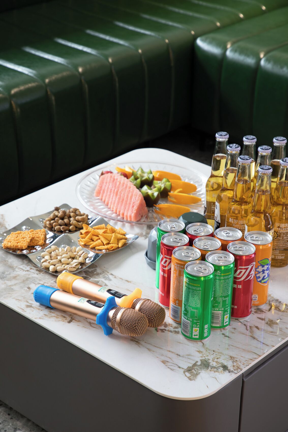 Una mesa con cubierta de mármol, con aperitivos, bebidas y un micrófono.