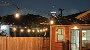 Puinen terassi, jossa on piknikpöytä ja koristeelliset valonauhat.