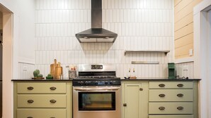 Keittiössä on ruostumattomasta teräksestä valmistettu liesi, sisäänrakennettu uuni ja liesituuletin. Siellä on myös kaksi vihreää kaappia, joissa on laatikoita, sekä työtaso, jonka päällä on erilaisia keittiötarvikkeita.