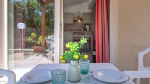 Ein Esstisch ist gedeckt mit Tellern, Gläsern und einer Vase mit Blumen.
