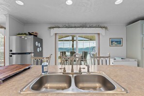 A kitchen with a double sink, a refrigerator, and a dining area with a view of the mountains. - Hot Tub & Breathtaking View on Dale Hollow Lake (Albany)