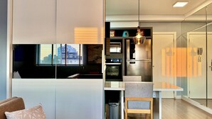Eine moderne Küche mit Einbauofen, Kühlschrank und einer Pendelleuchte.
