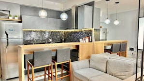 Una cucina moderna con un'isola centrale, sgabelli da bar e un divano.
