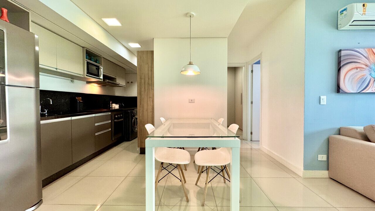 A modern kitchen with a central island, stainless steel appliances, and a dining area with two chairs.