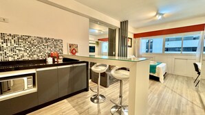 A modern kitchen with a glass island, stainless steel appliances, and a tiled backsplash.