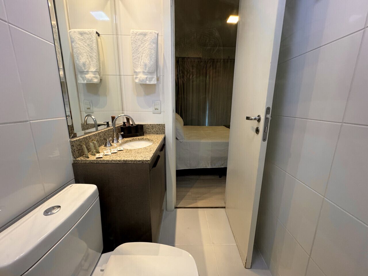 A compact bathroom with a toilet, sink, and shower area.