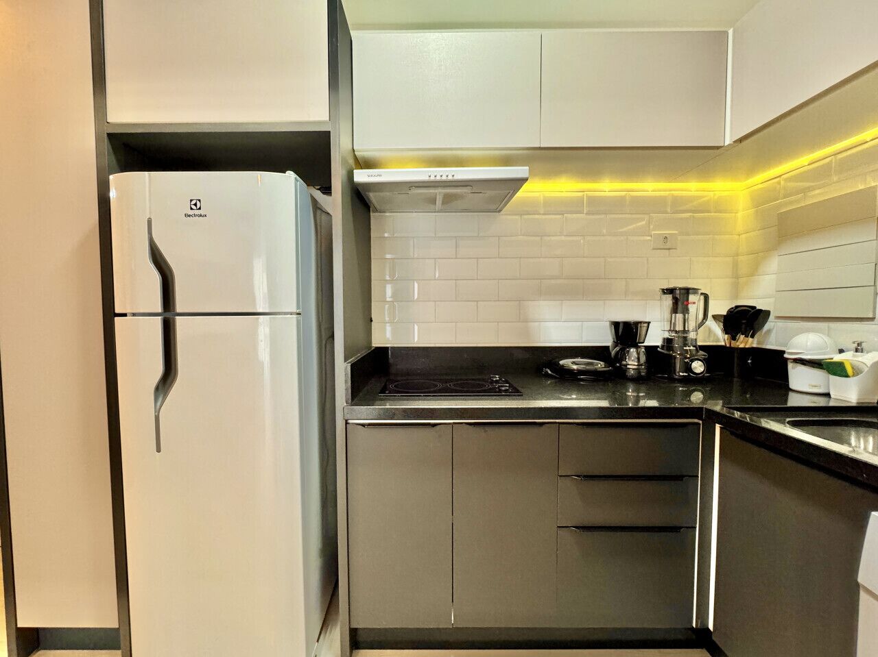 Eine moderne Küche mit Einbaukühlschrank, Herd und Mikrowelle.