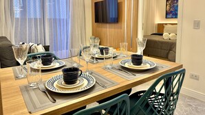 A dining area with a wooden table set for four, including plates, glasses, and cutlery.