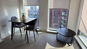 Eine moderne Wohnung mit Essbereich, großen Fenstern und Blick auf die Stadtlandschaft.