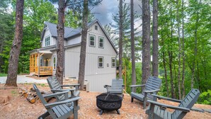A house with a deck, outdoor seating, and a fire pit.
