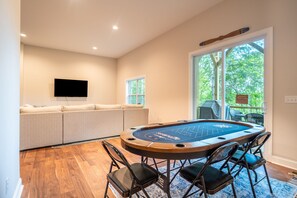 Ein Zimmer mit Poolbillard, einer Couch und einem Fernseher.