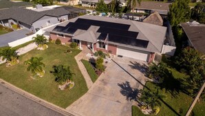 A residential property with a garage, a driveway, and a lawn with palm trees. - Dream Gateway, Luxury, Exclusive (Bradenton)