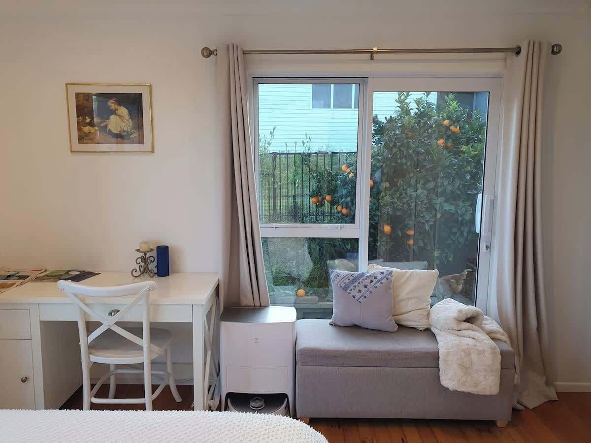 Work desk and bench seat beneath window with garden view