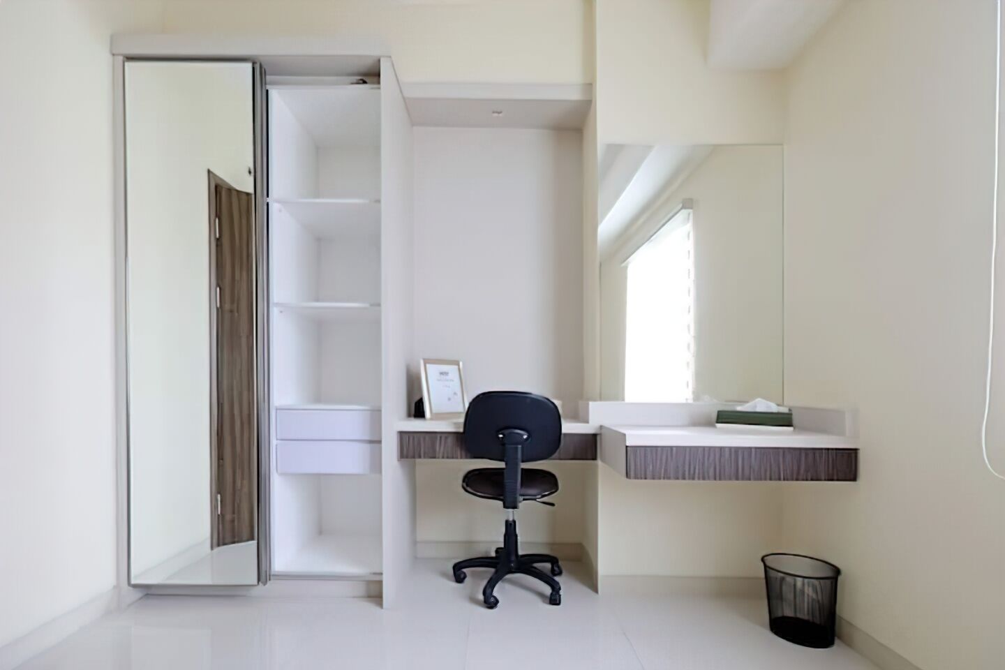 Un espacio de oficina moderno y minimalista con un escritorio, una silla y estanterías.