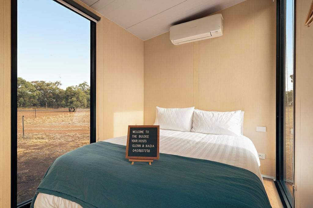 Un dormitorio con una cama, una ventana y un letrero de bienvenida.