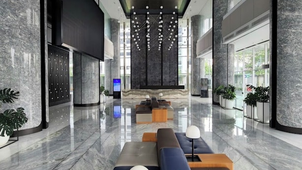 A modern lobby with marble flooring, seating areas, and a large digital display. - The Smith Luxury SkyView Apartments (Tangerang)