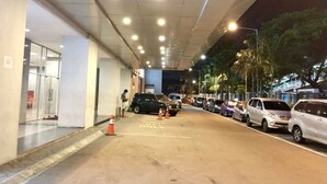 Un'area di parcheggio con auto e l'ingresso di un edificio.