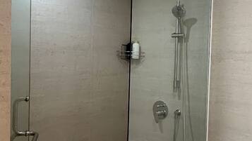A modern bathroom with a glass shower enclosure, a bathtub, and a toilet.