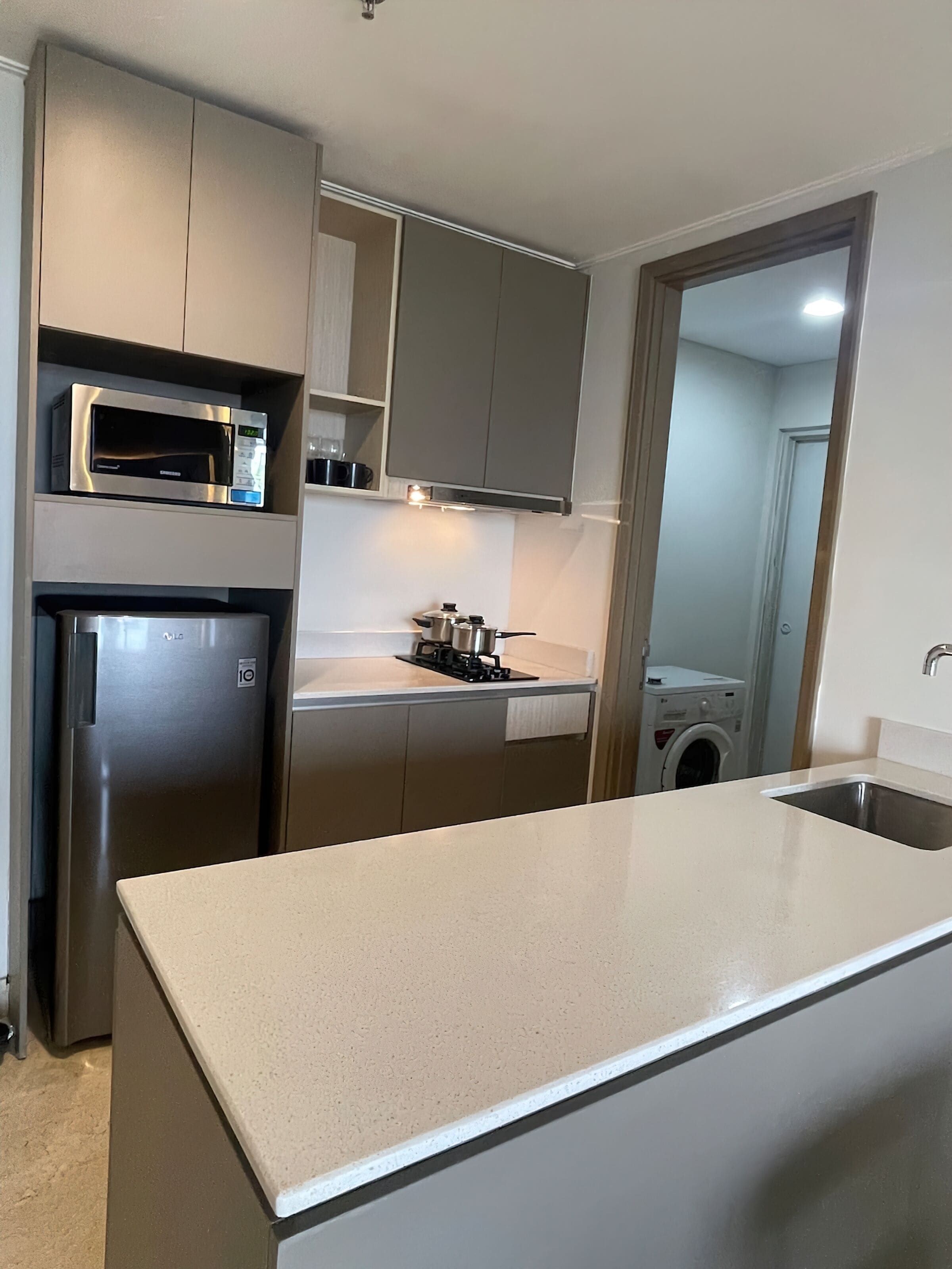 A modern kitchen with a stainless steel refrigerator, microwave, and stove.