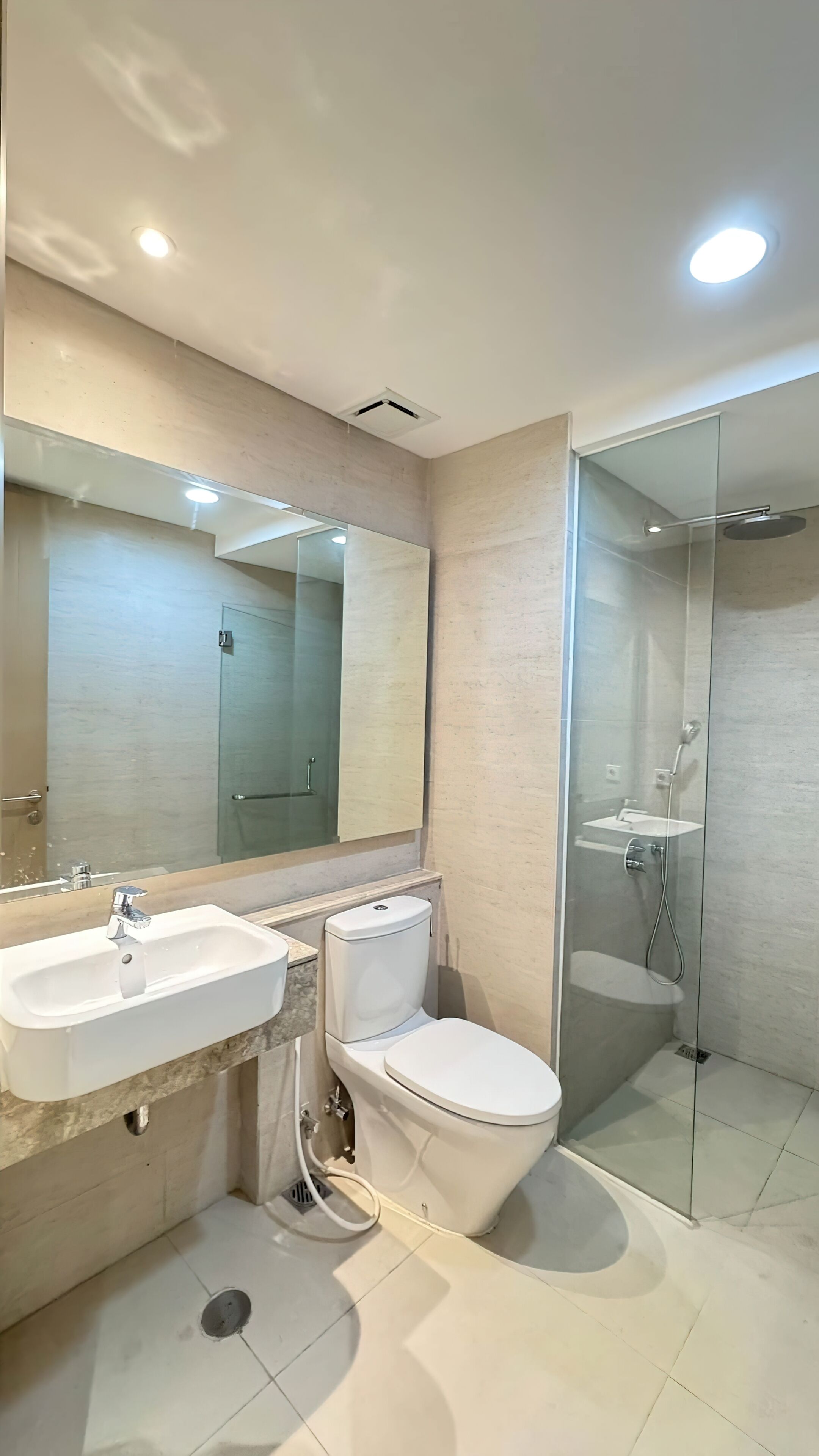 A modern bathroom with a sink, toilet, and glass-enclosed shower.