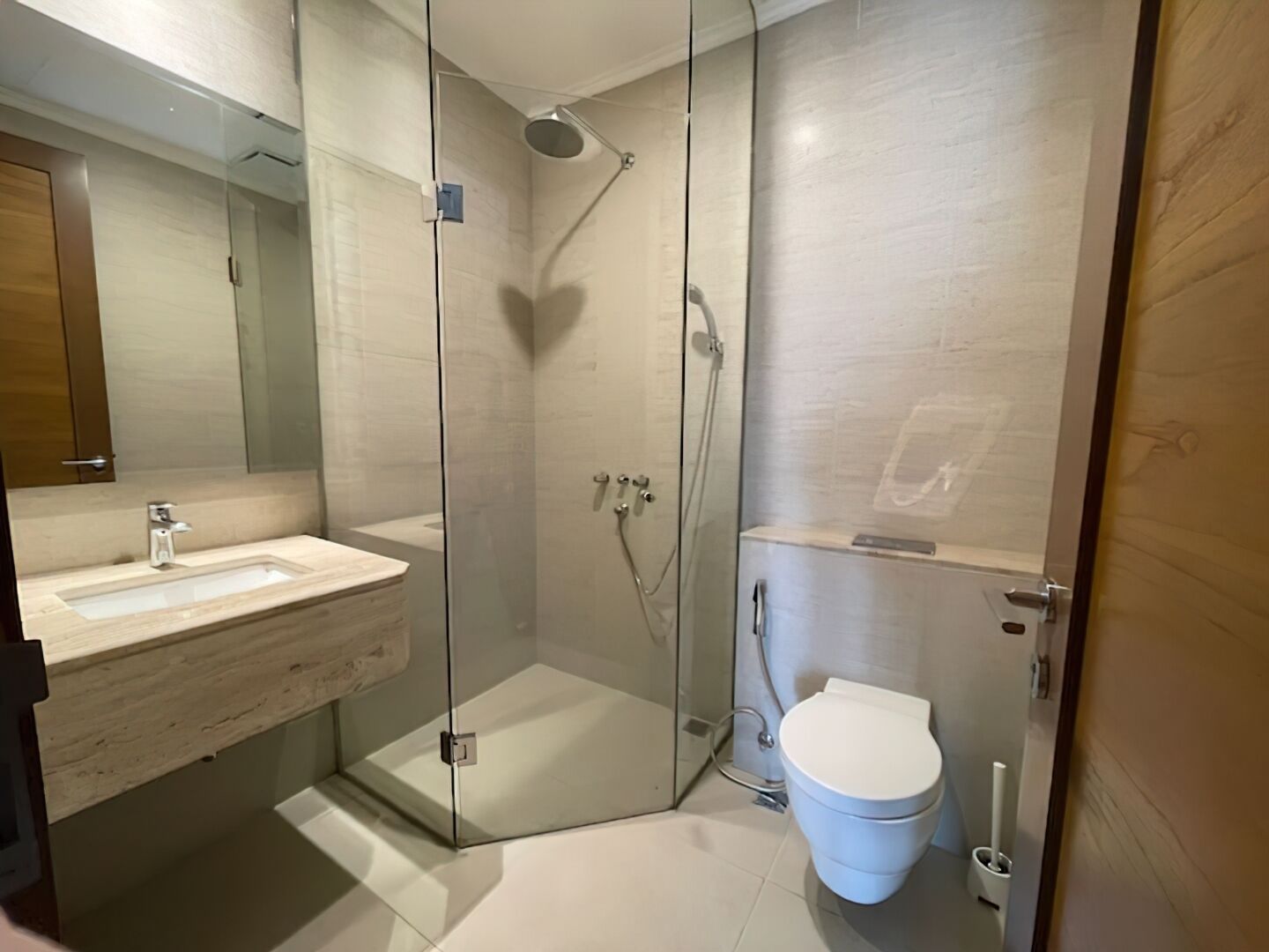 Une salle de bain moderne avec une douche à parois de verre, un lavabo blanc et des toilettes.