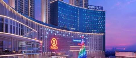 A modern hotel with a central atrium, a Christmas tree, and a large illuminated sign.