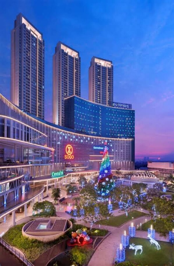 Un hotel moderno con un atrio central, un árbol de Navidad y un gran letrero iluminado.