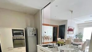 A modern kitchen with white cabinetry, a built-in oven, and a refrigerator. - Somerset Berlian Suites Jakarta (Jakarta)