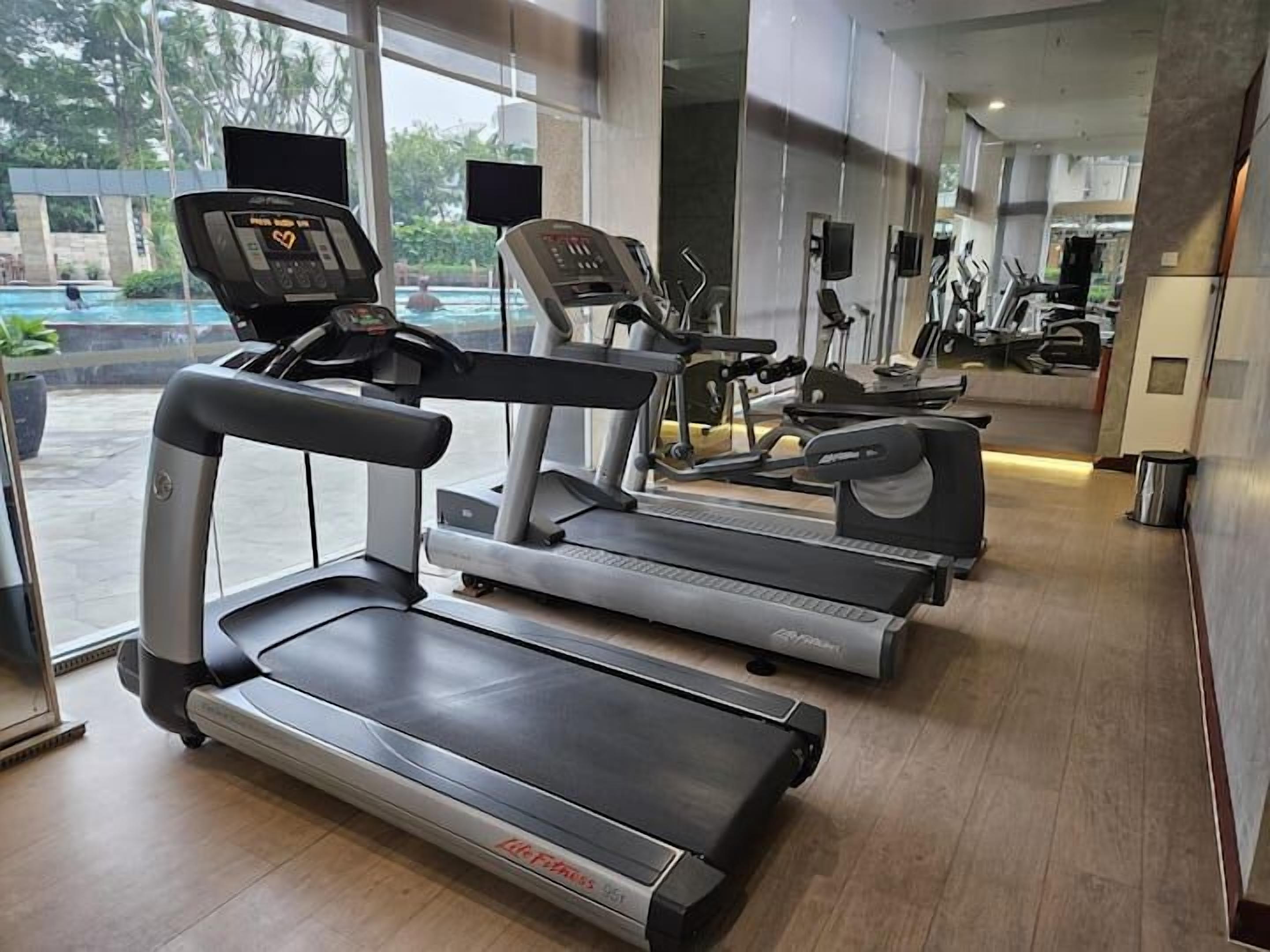 A gym with treadmills, elliptical machines, and stationary bikes.