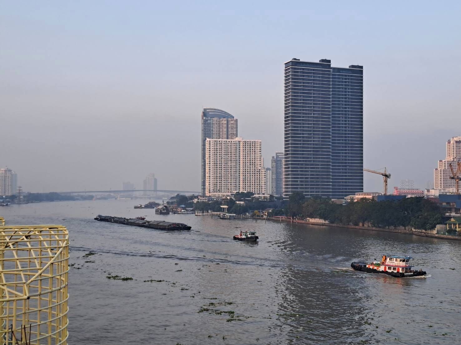 Un río con barcos y un paisaje urbano al fondo.