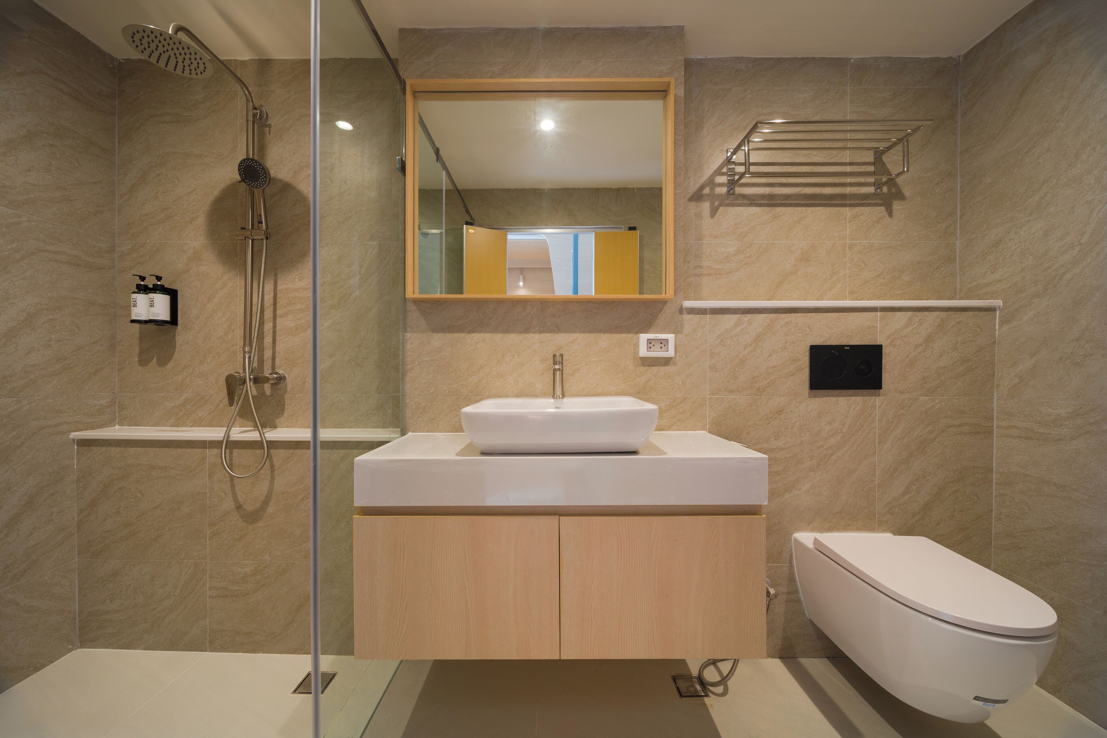A modern bathroom with a glass-enclosed shower, a white sink with a rectangular basin, and a toilet.