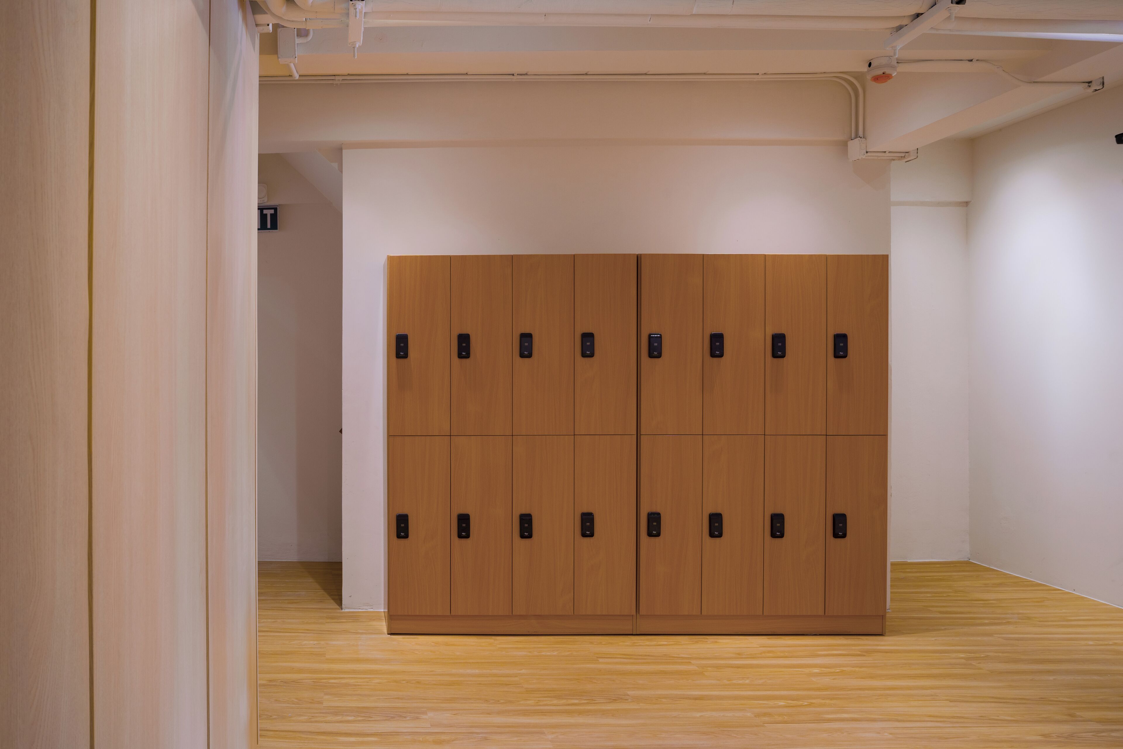 Une pièce dotée d’une grande armoire en bois, d’un plancher en bois et de murs blancs.