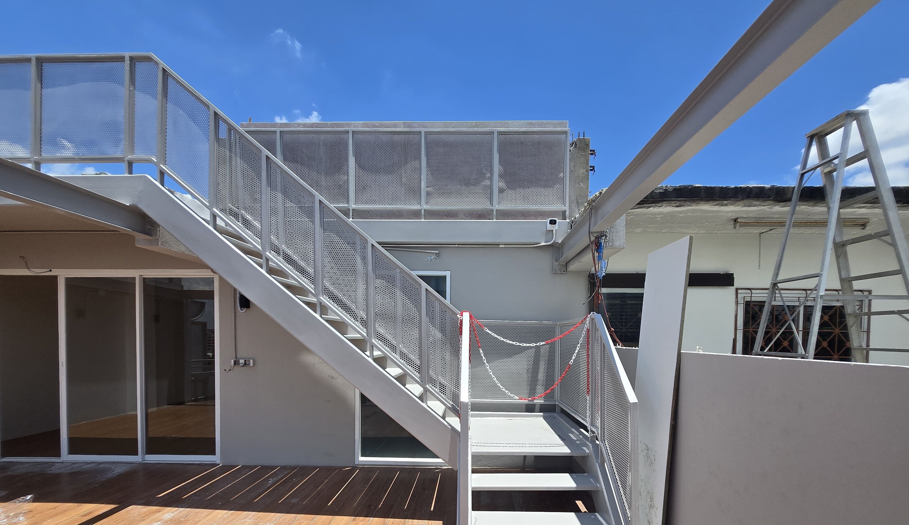 A multi-level outdoor staircase with metal railings and a chain barrier.