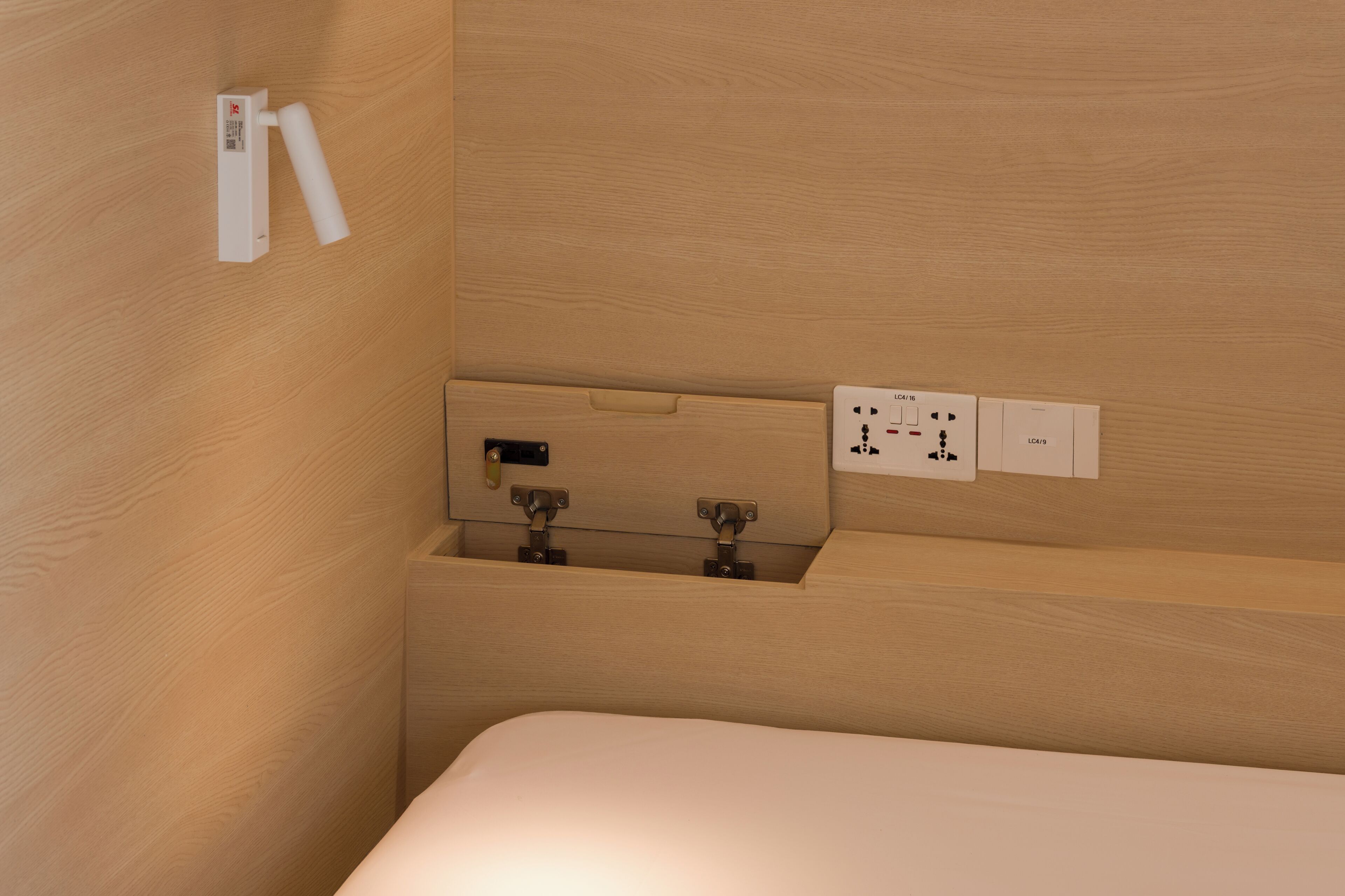 A wooden wall with a white electrical outlet and a switch.