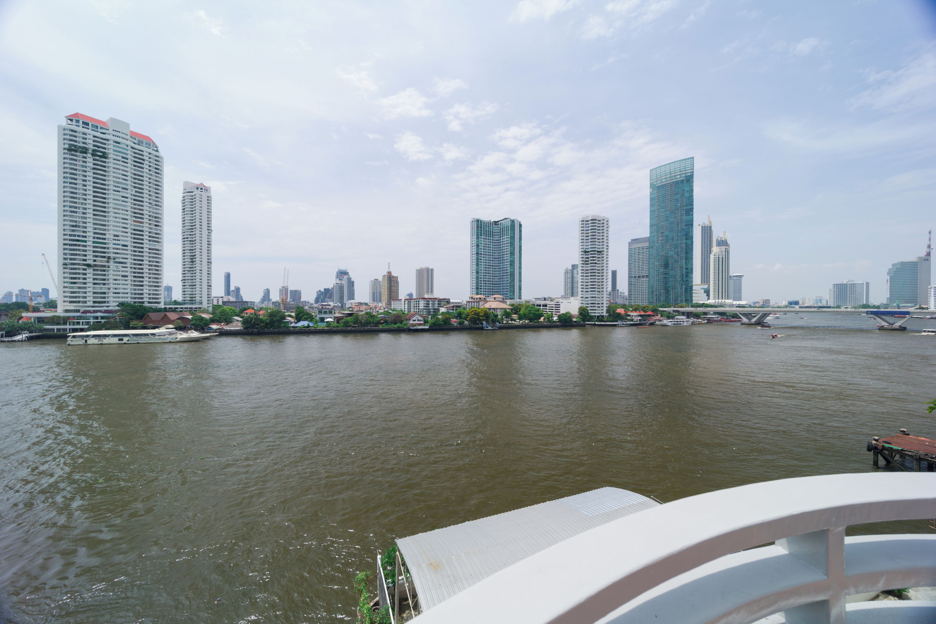A river with modern high-rise buildings on the opposite bank.