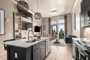 Et moderne køkken med en central ø, indbyggede hylder og et spiseområde med udsigt.