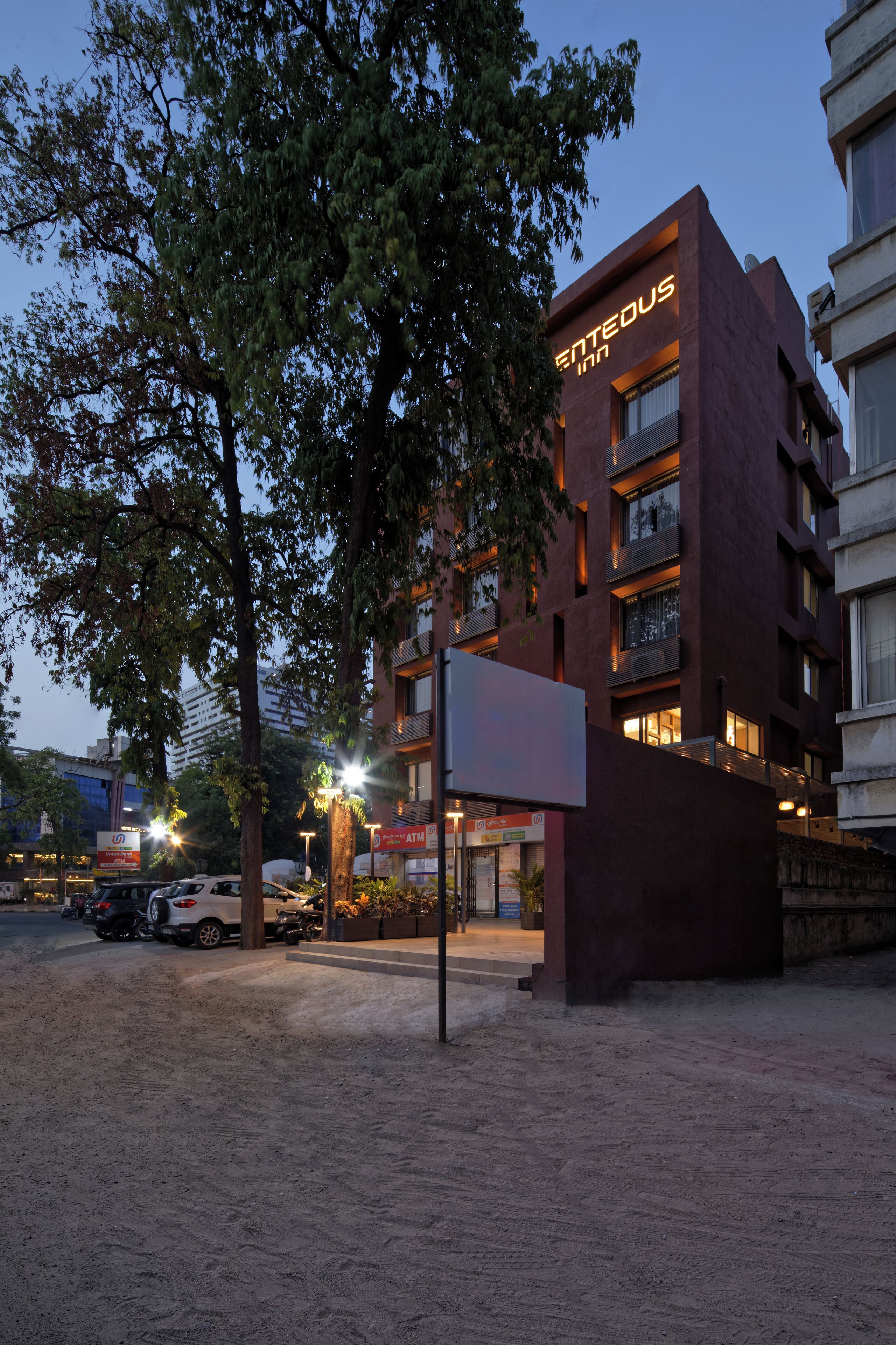 Un bâtiment moderne, sur lequel on peut lire l'inscription « ENTEDUS INN », à la tombée de la nuit.